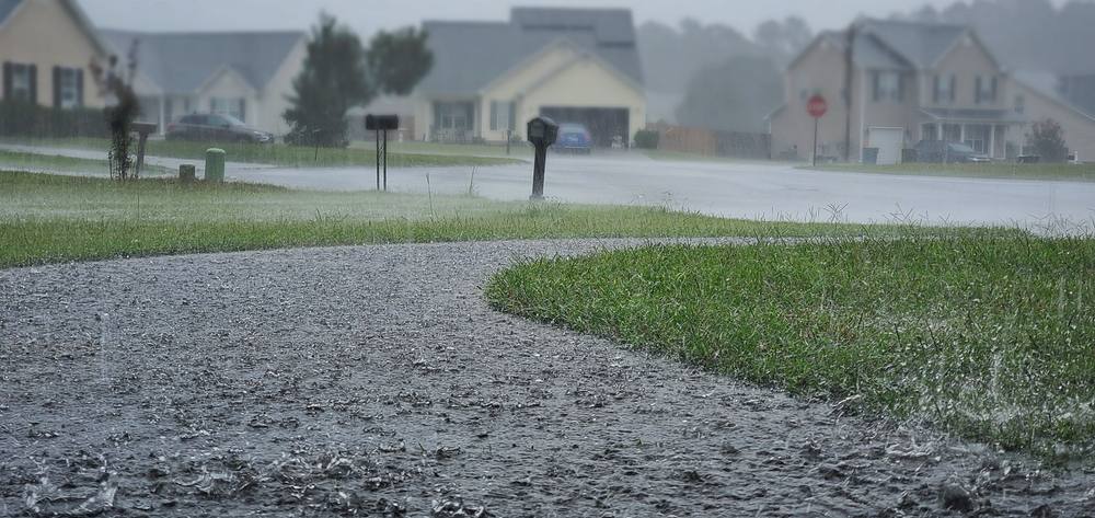 Heavy rain falling on a residential street.
